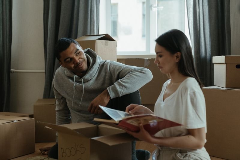 Casal desembalando caixas em uma casa nova